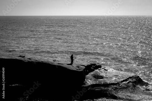 black and white photo of silhouette of a man overlooking the ocean in san diego