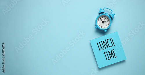 Blue alarm clock and paper reminder lunch time. photo