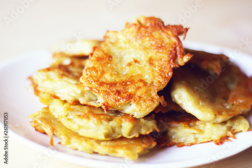 Homemade potato pancakes in a white plate on a wooden table