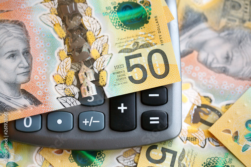 Australian fifty dollar bill over a calculator. The new 2019 issue is designed to deter counterfeiting, the note is polymer and water resistant with a clear holographic strip photo