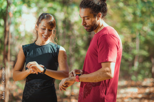 Young couple Looking at Their Smart Watches After Outdoor Training photo