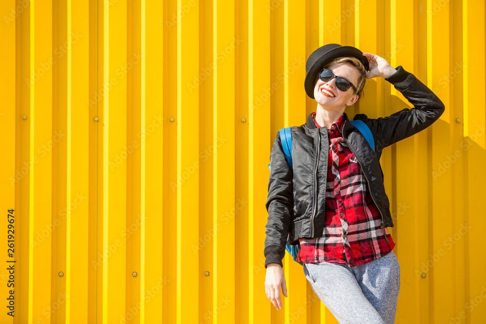 Happy young traveler woman enjoying sunny day over urban city wall Happy young traveler woman enjoying sunny day over urban city wall