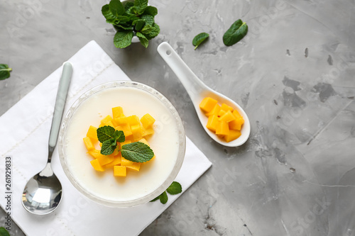 Bowl of delicious panna cotta on grey table