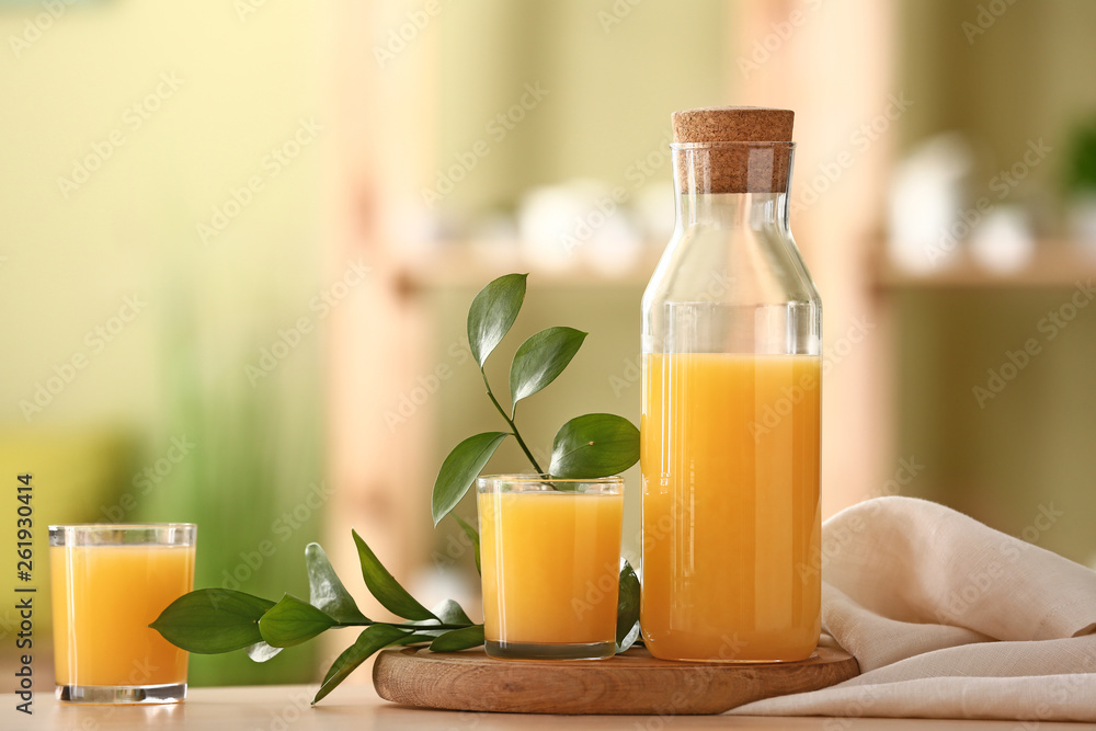 Bottle and glasses of tasty orange juice on table - obrazy, fototapety, plakaty 