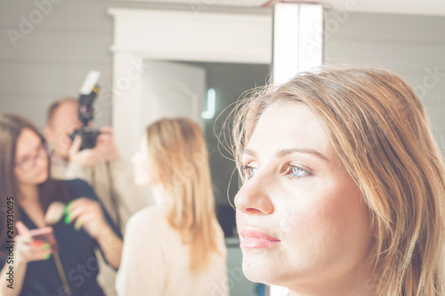 young, beautiful blonde woman put on make-up in a beauty salon, fashion concept