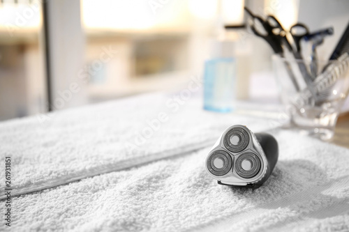 Картината върху платно Towel with electric shaver on table