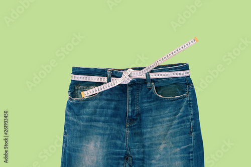 Jeans with a measuring tape. Weight loss concept photo