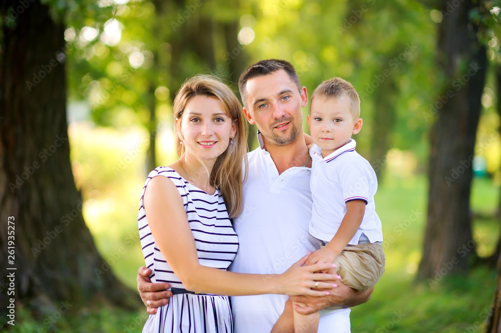 Fototapeta premium Loving family. Happy young family spending time together having fun in summer park, people concept. Family еnjoying time together