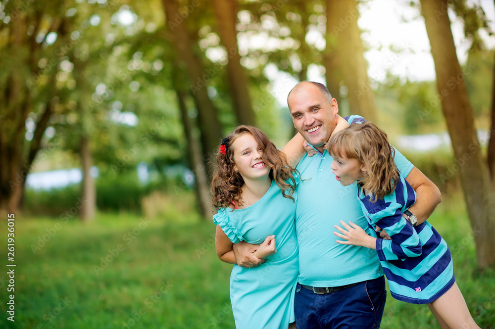 family is having fun. Dad plays with his daughters in a beautiful evening park. people concept. Family enjoy time together family is having fun. Dad plays with his daughters in a beautiful evening park. people concept. Family enjoy time together