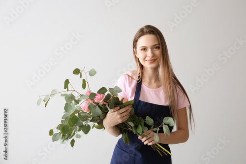 Florist with bouquet against light background