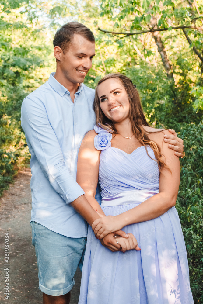 Couple in love smiling and hugging in trees tunnel. Man holding hands around woman. Tender and affectionate couple standing on nature background. Young beautiful couple. Happy couple in love Couple in love smiling and hugging in trees tunnel. Man holding hands around woman. Tender and affectionate couple standing on nature background. Young beautiful couple. Happy couple in love