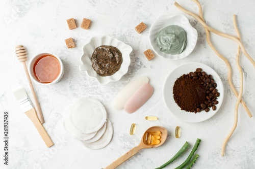 Homemade skin care and body scrubs and mask with natural ingredients aloe vera, lemon, coffee, sugar, clay, honey set up on white wooden background with flat lay