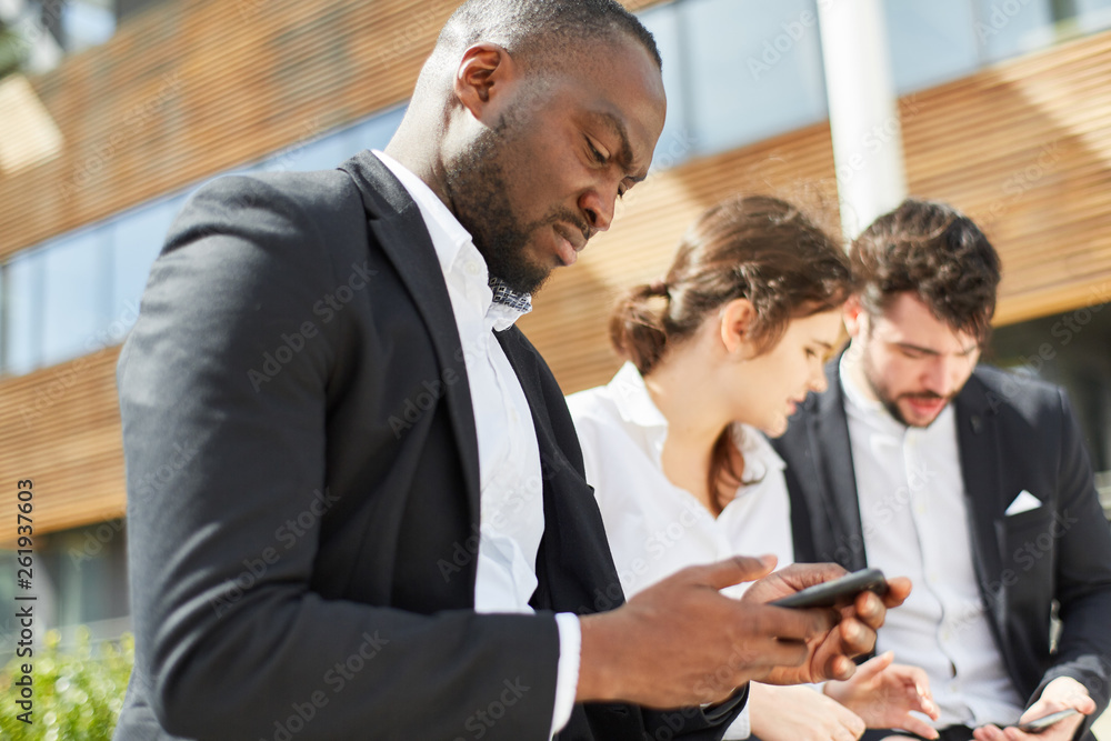 Afrikanischer Geschäftsmann liest eine SMS Afrikanischer Geschäftsmann liest eine SMS