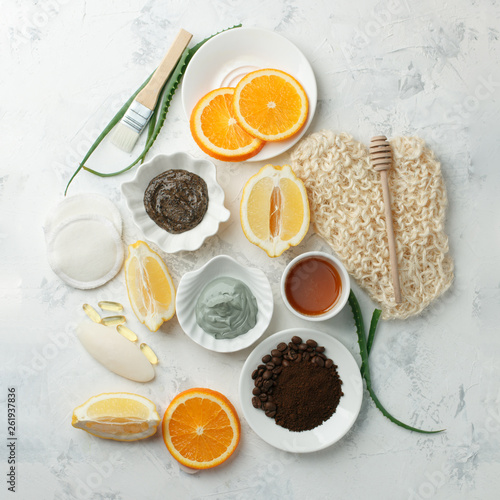 Homemade skin care and body scrubs and mask with natural ingredients aloe vera, lemon, coffee, oranges, clay, honey set up on white wooden background with flat lay