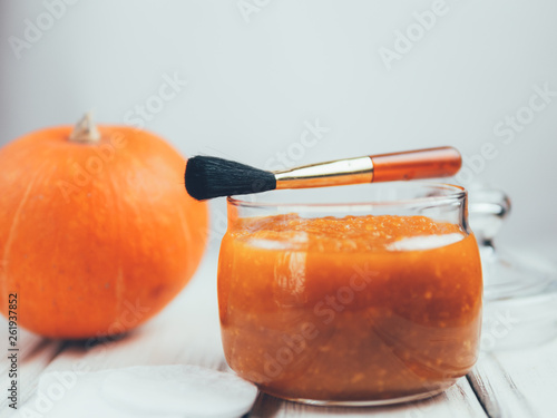 Homemade pumpkin face mask . Home cosmetics with their hands , brush for application on a white background