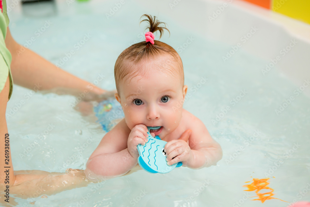 infant swimming,Mother teaching baby to swim in water pool,Little baby's first swim infant swimming,Mother teaching baby to swim in water pool,Little baby's first swim