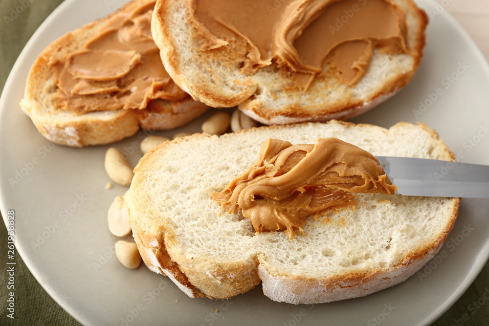 Bread with tasty peanut butter on plate, closeup Bread with tasty peanut butter on plate, closeup
