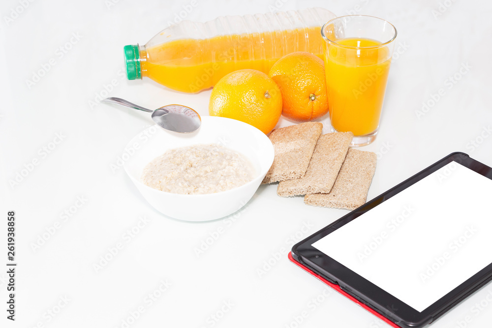 Healthy Breakfast with muesli and orange juice. Top view on light background with tablet to copy space. Healthy Breakfast with muesli and orange juice. Top view on light background with tablet to copy space.