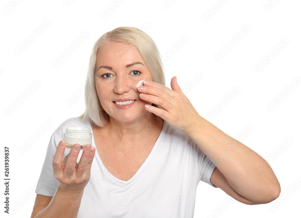 Mature woman applying facial cream on white background Mature woman applying facial cream on white background