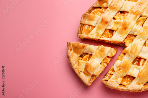 Tasty orange pie on color background photo