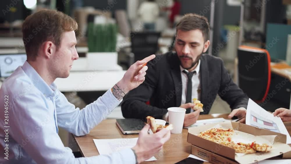 Modern office, office workers at the meeting eat pizza, discuss working information, team buildings. Modern office, office workers at the meeting eat pizza, discuss working information, team buildings.