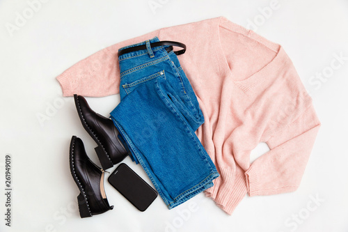 Women's fashion clothing and accessories. Female youth collage on white background top view. A flat lay-out in feminine style looks with a warm sweater, jeans, shoes. Top view. 