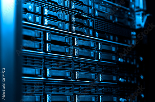 Close up blade server equipment rack in big data center with blurred side frame cold blue tone