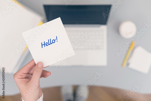 Woman clerk sitting holding note paper sticker with hello word. Business concept. Concept.