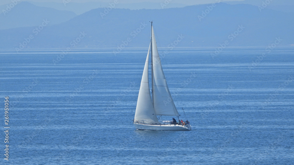 Zoom photo of sail boat sailing the Aegean deep blue sea
