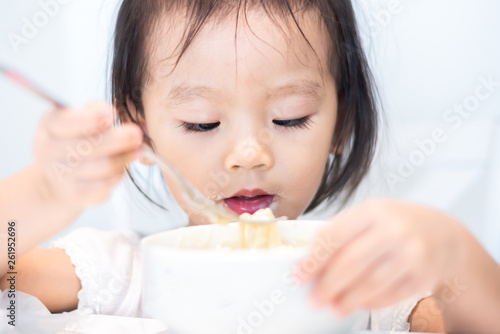 Asian little baby child eating noodle and enjoy breakfast by herself