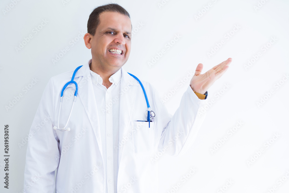 Middle age doctor man wearing stethoscope and medical coat over white background smiling cheerful presenting and pointing with palm of hand looking at the camera. Middle age doctor man wearing stethoscope and medical coat over white background smiling cheerful presenting and pointing with palm of hand looking at the camera.