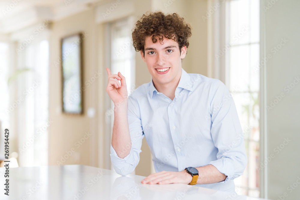 Young business man with curly read head with a big smile on face, pointing with hand finger to the side looking at the camera. Young business man with curly read head with a big smile on face, pointing with hand finger to the side looking at the camera.