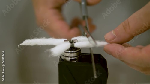 Cutting the cotton of the coil for the Vape Mod vaping photo