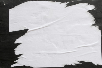 A sheet of white paper glued on a black wall.