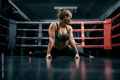 Vászonkép Beautiful caucasian boxer girl doing exercises on ring floor.