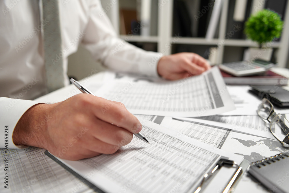 Businessman working at office and calculating finance, reads and writes reports. Business financial accounting concept. Businessman working at office and calculating finance, reads and writes reports. Business financial accounting concept.
