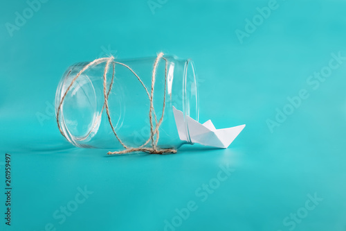 Freedom, release and dreams concept. Paper plane in jar. Isolated on blue background. Copy space