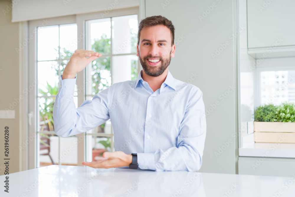 Handsome business man gesturing with hands showing big and large size sign, measure symbol. Smiling looking at the camera. Measuring concept. Handsome business man gesturing with hands showing big and large size sign, measure symbol. Smiling looking at the camera. Measuring concept.