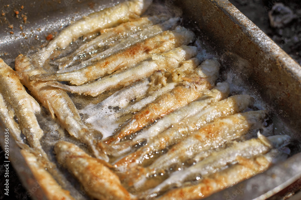 freshly smelt fry on a baking tray in the open air freshly smelt fry on a baking tray in the open air