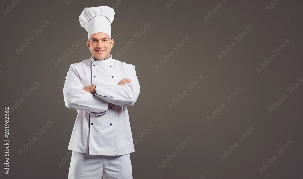 Chef in white uniform is smiling.
