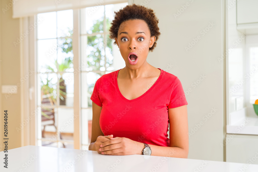 Young beautiful african american woman at home afraid and shocked with surprise expression, fear and excited face.