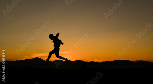 Silhouette of a jumping man at sunset, Concept lifestyle freedom vacation travel. © banphote