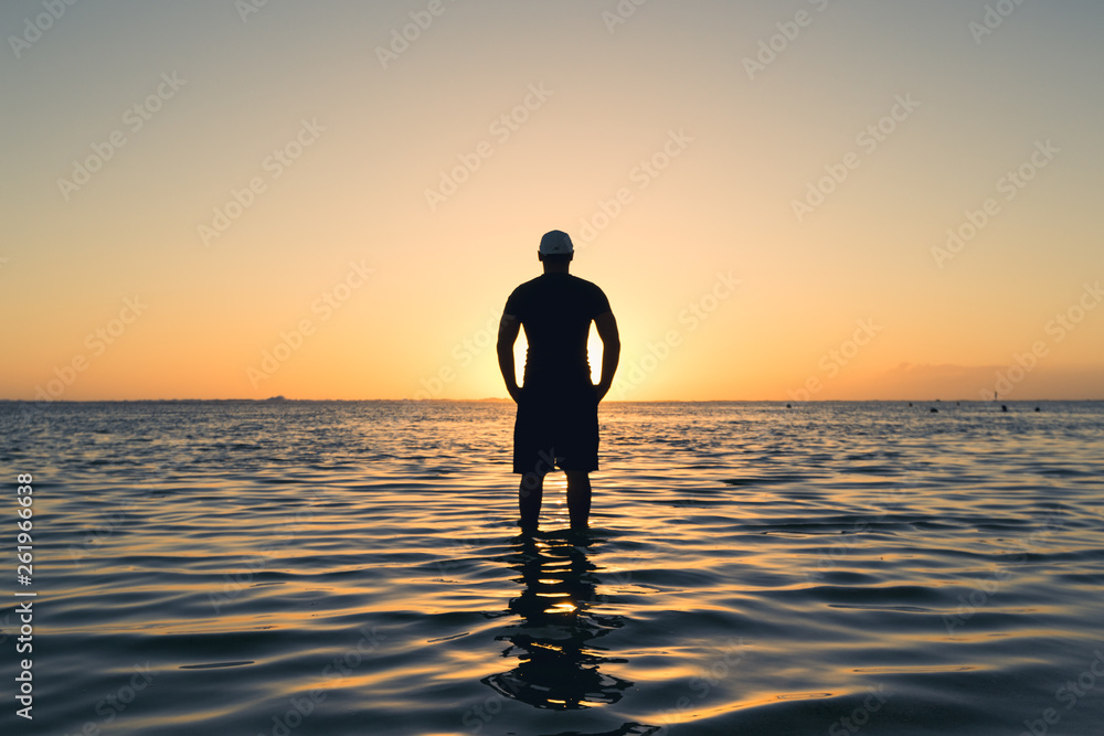 man standing backlight sunset lighting back view summer evening beach lens flare man standing backlight sunset lighting back view summer evening beach lens flare