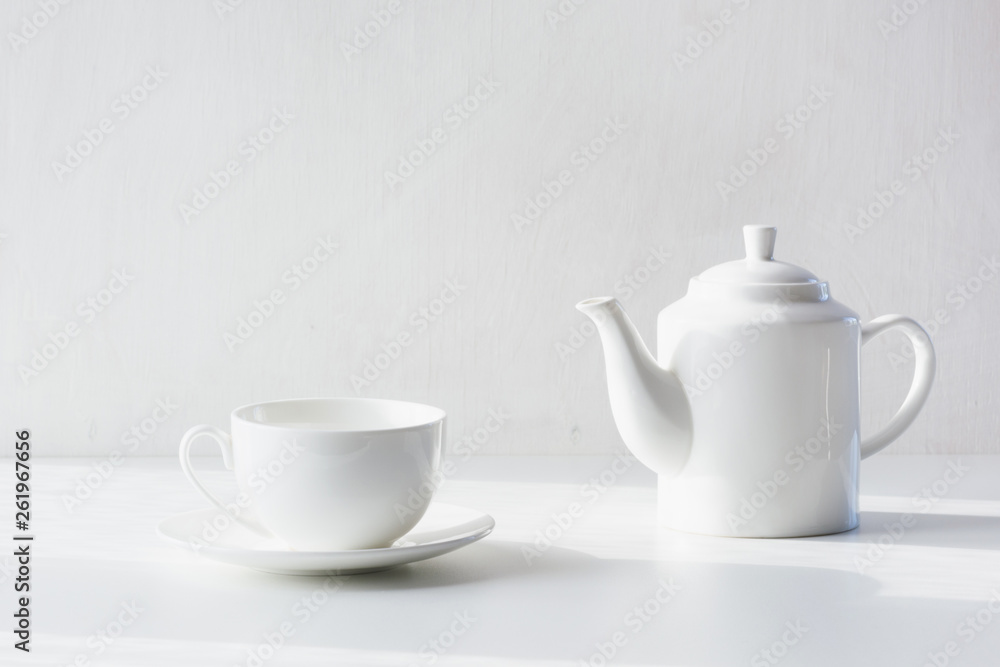 Set of white utensils for tea, white teapot and cup Set of white utensils for tea, white teapot and cup