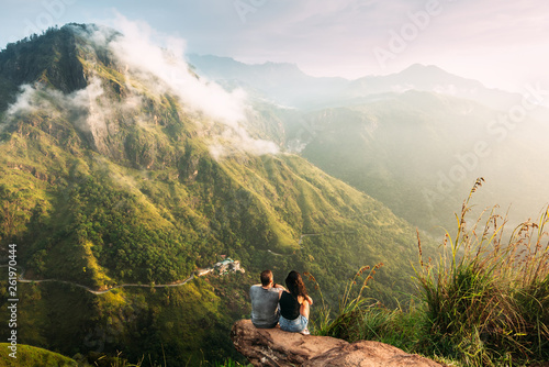 The couple greets the sunrise in the mountains. Man and woman in the mountains. Wedding travel. The couple travels around Asia. Travel to Sri Lanka. Serpentine in the mountains. People greet the dawn