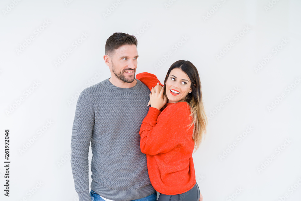 Young beautiful couple togheter over isolated background looking away to side with smile on face, natural expression. Laughing confident. Young beautiful couple togheter over isolated background looking away to side with smile on face, natural expression. Laughing confident.