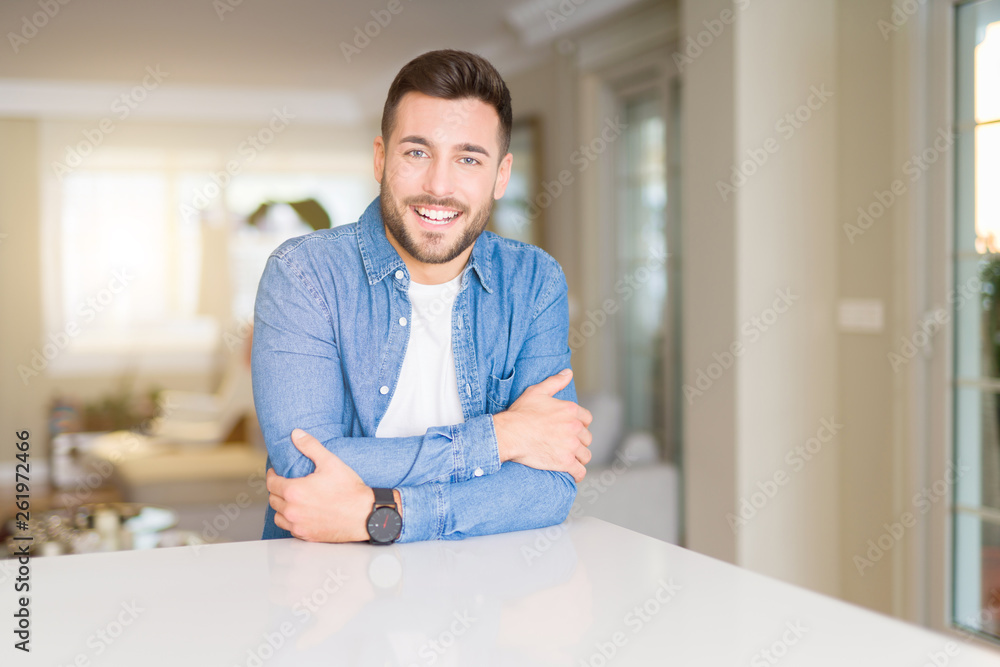 Young handsome man at home happy face smiling with crossed arms looking at the camera. Positive person. Young handsome man at home happy face smiling with crossed arms looking at the camera. Positive person.