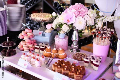 Delicious candy bar with cupcakes, cake pops, macaroons and other sweets