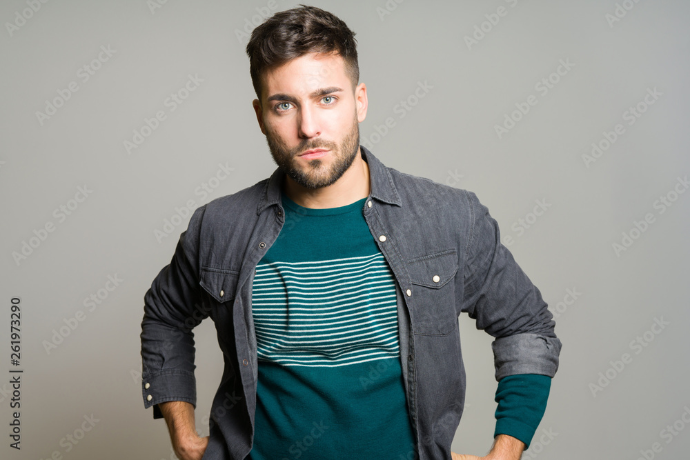 Fototapeta premium Young handsome man possing and modeling over grey isolated background
