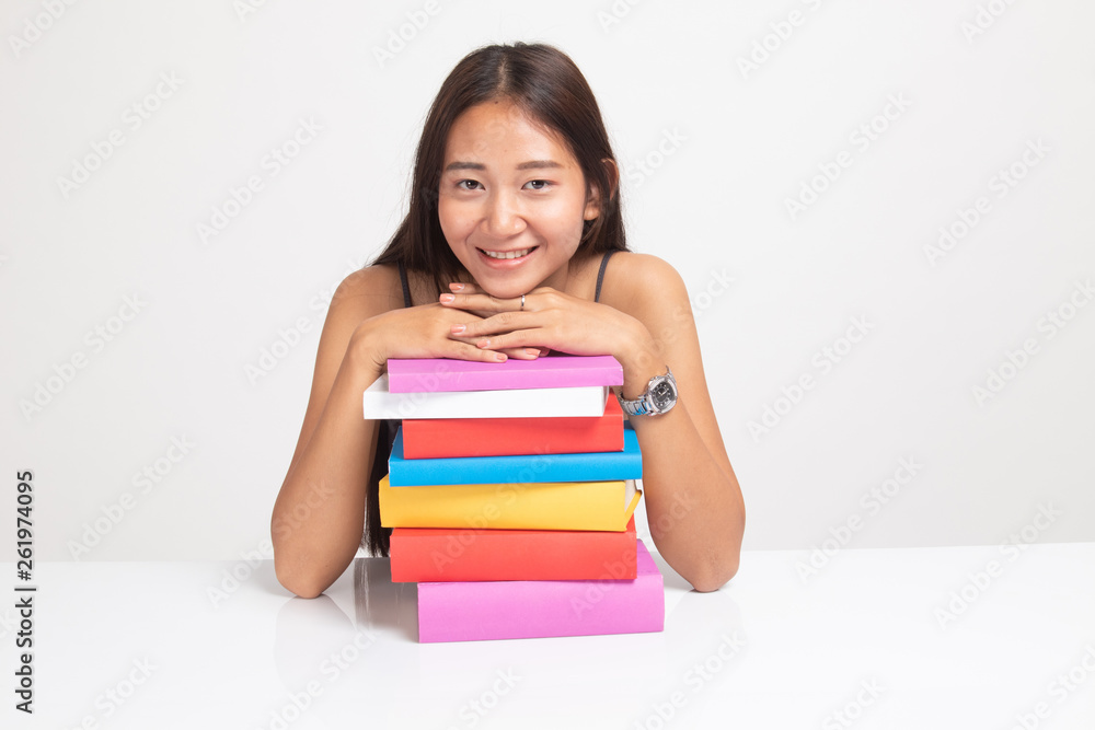 Happy young Asian woman read a book with books on table. Happy young Asian woman read a book with books on table.